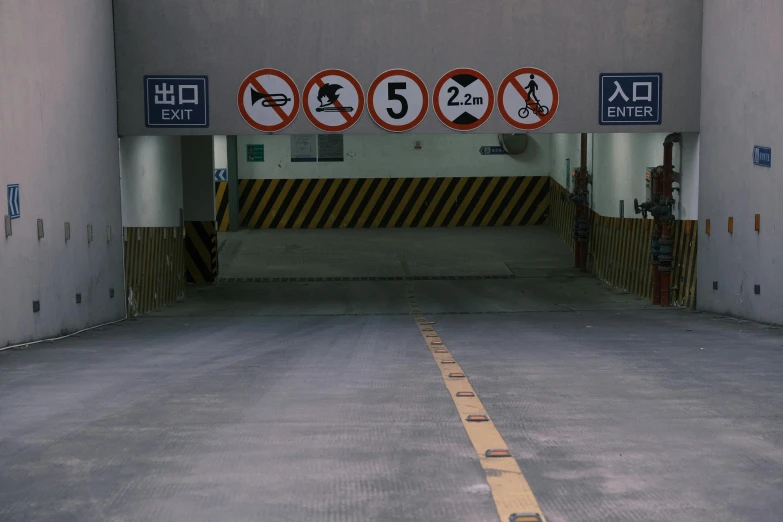 a road with a row of signs in a parking garage