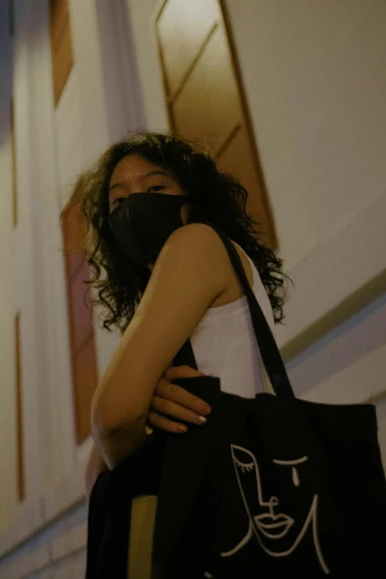 woman wearing a black mask carries her shopping bag
