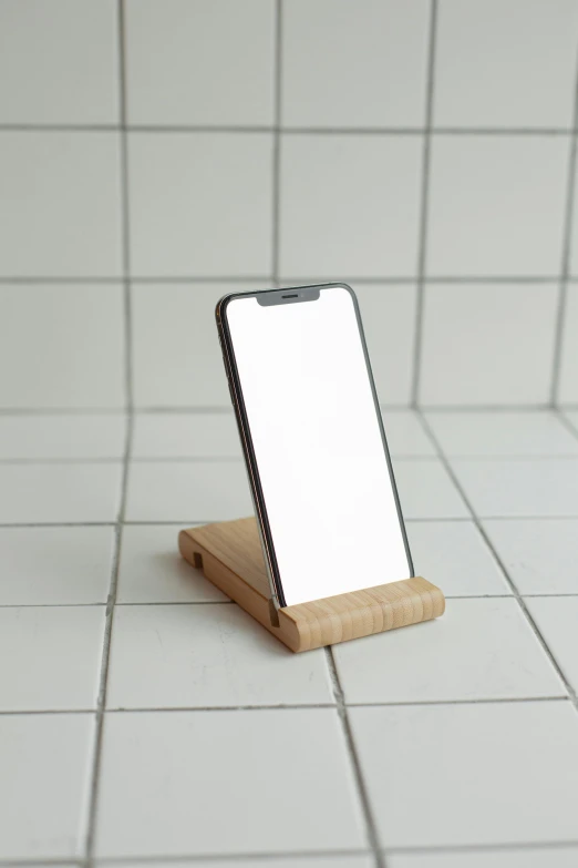 an iphone is standing on top of a small wooden stand