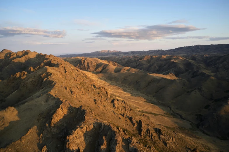 an aerial view of a rocky mountain with a sky background