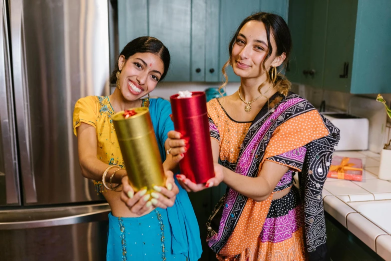 two women standing in a kitchen holding presents