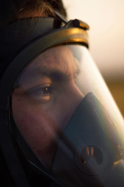 a man wearing a helmet and goggles looking through a mirror