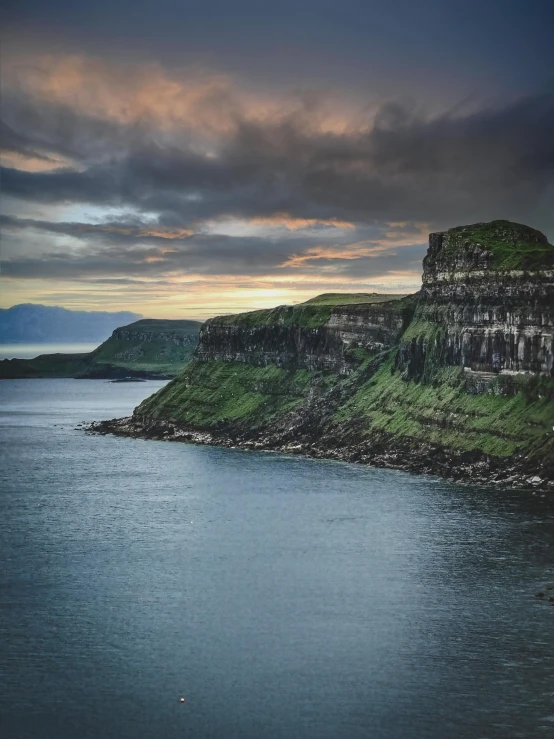 a boat on the water next to a large mountain