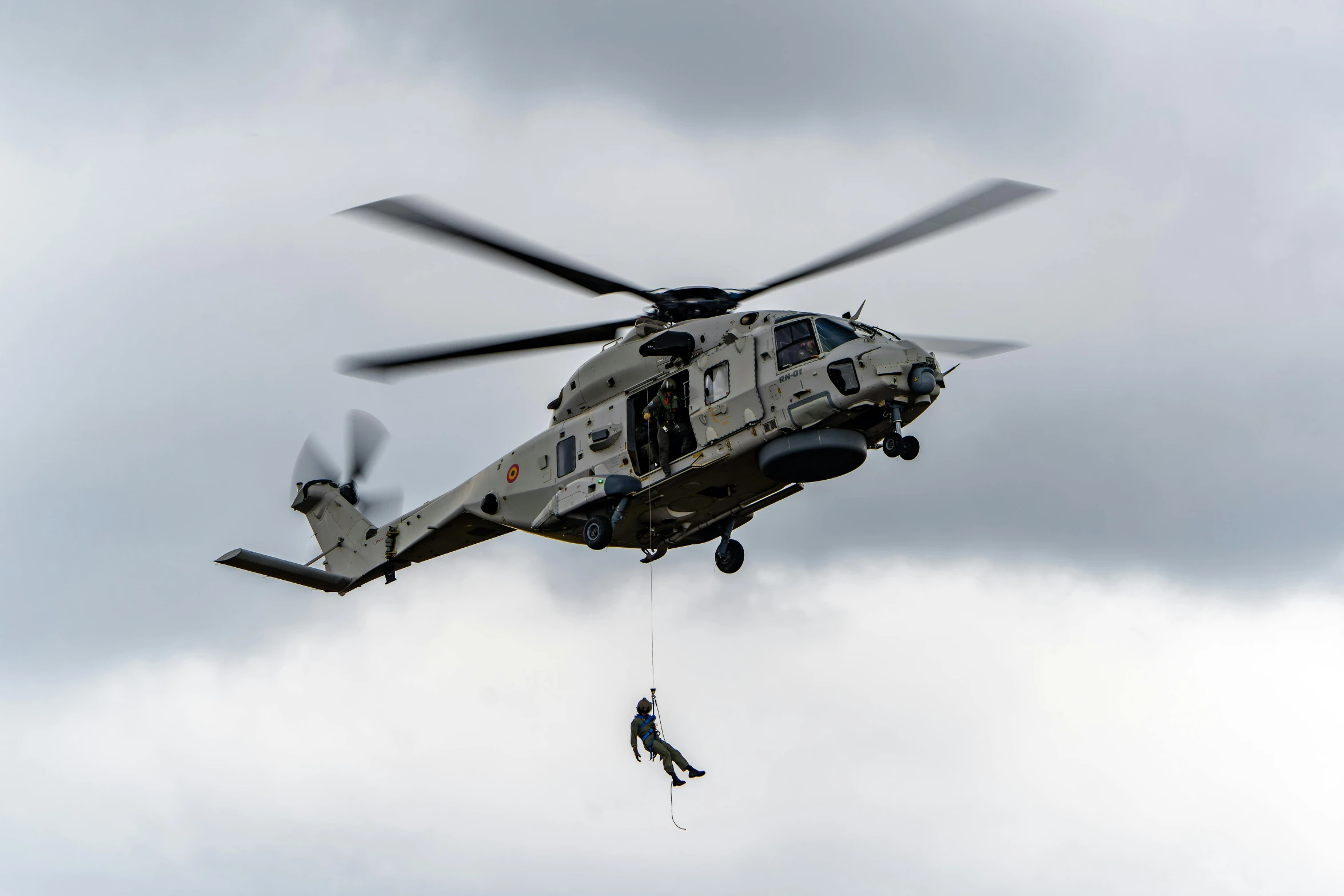 two people falling from a helicopter and being hoisted