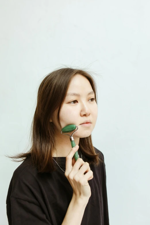 a young woman brushes her hair in front of a white background