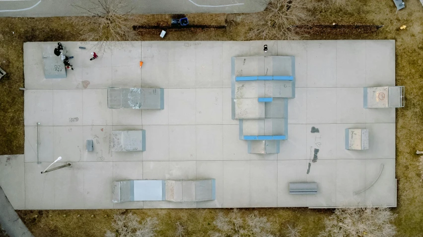 an aerial view of several square structures on an asphalt ground