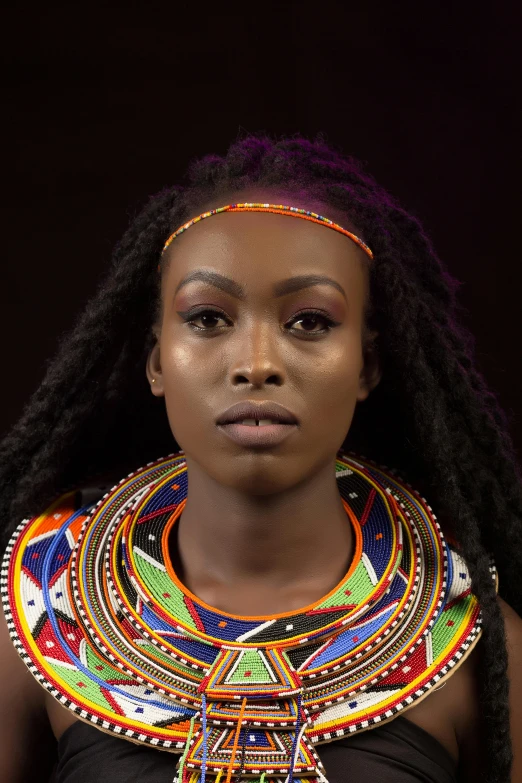 an african woman with a very large multicolored piece on her necklace