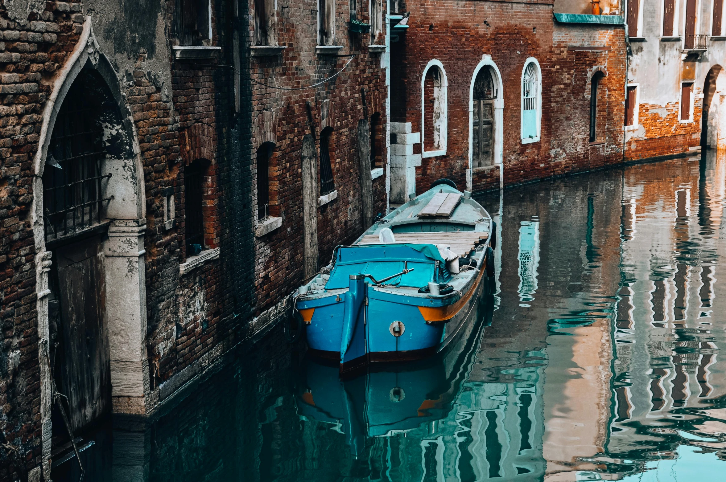 a boat sits alone in a canal between two buildings