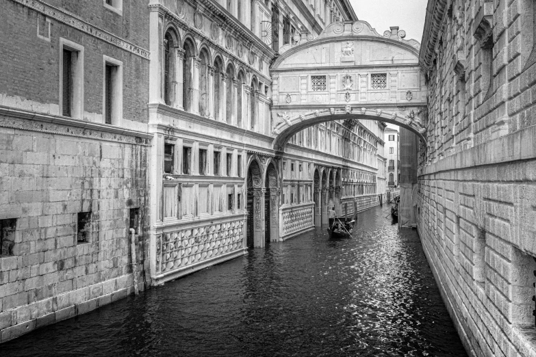 a bridge over a narrow canal next to buildings