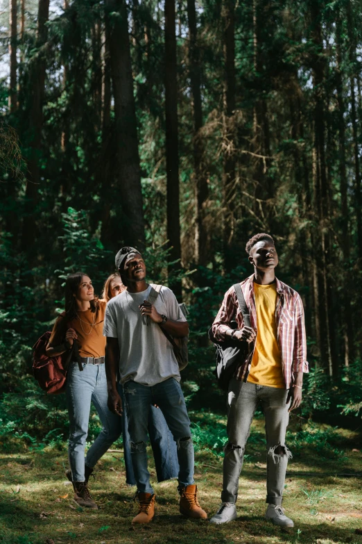 four people standing in the forest with trees