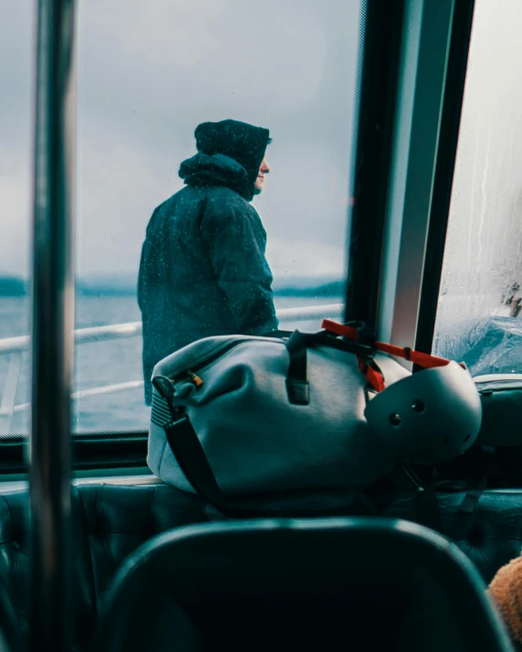 man sitting in a seat on the side of a boat with a helmet on it