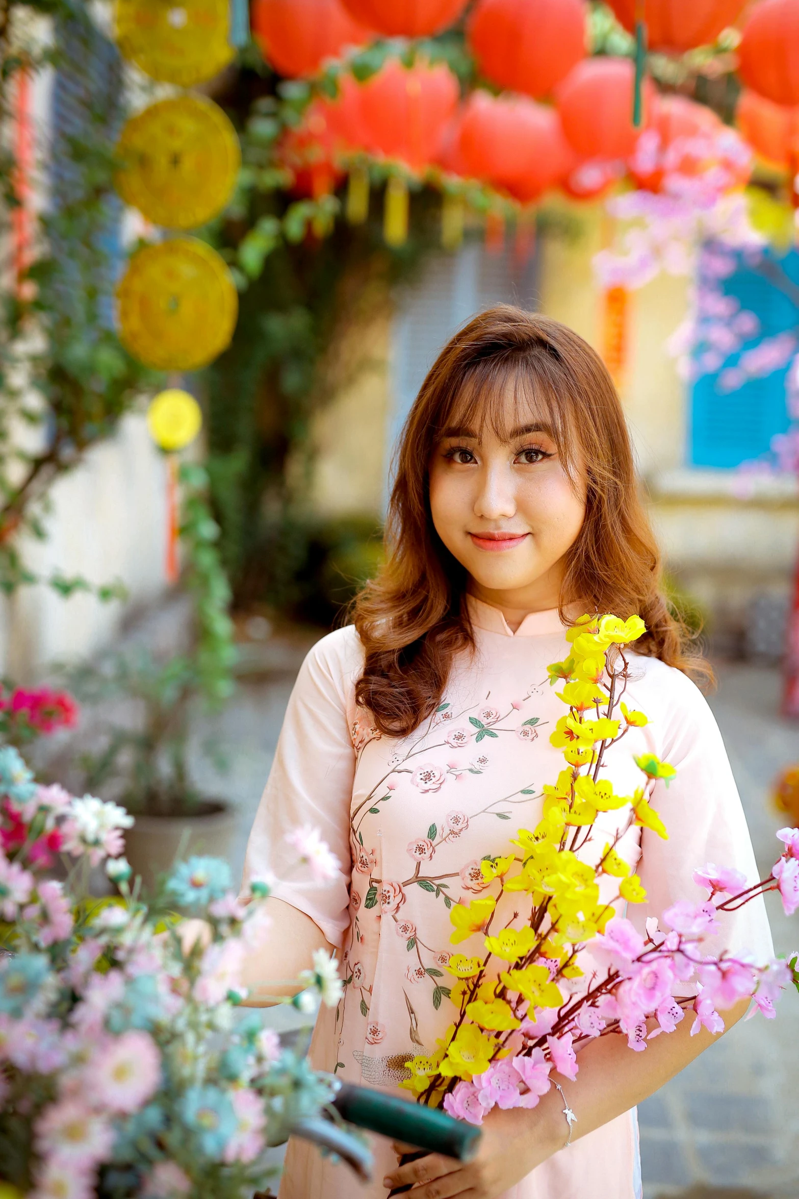 an asian woman with flowers in front of colorful lanterns