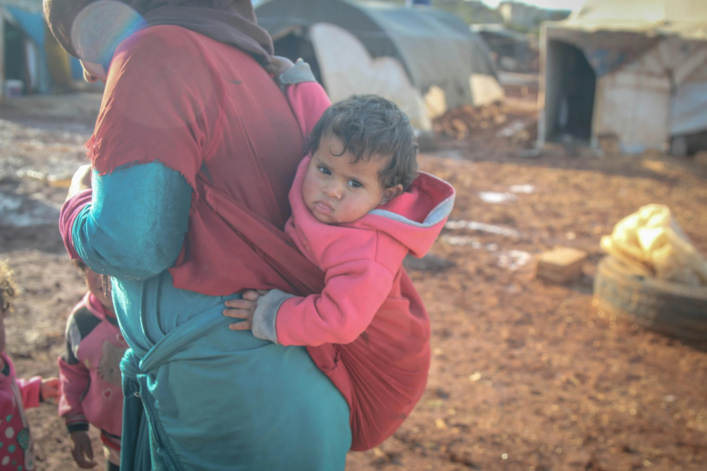 there is a woman holding a child in a back pack