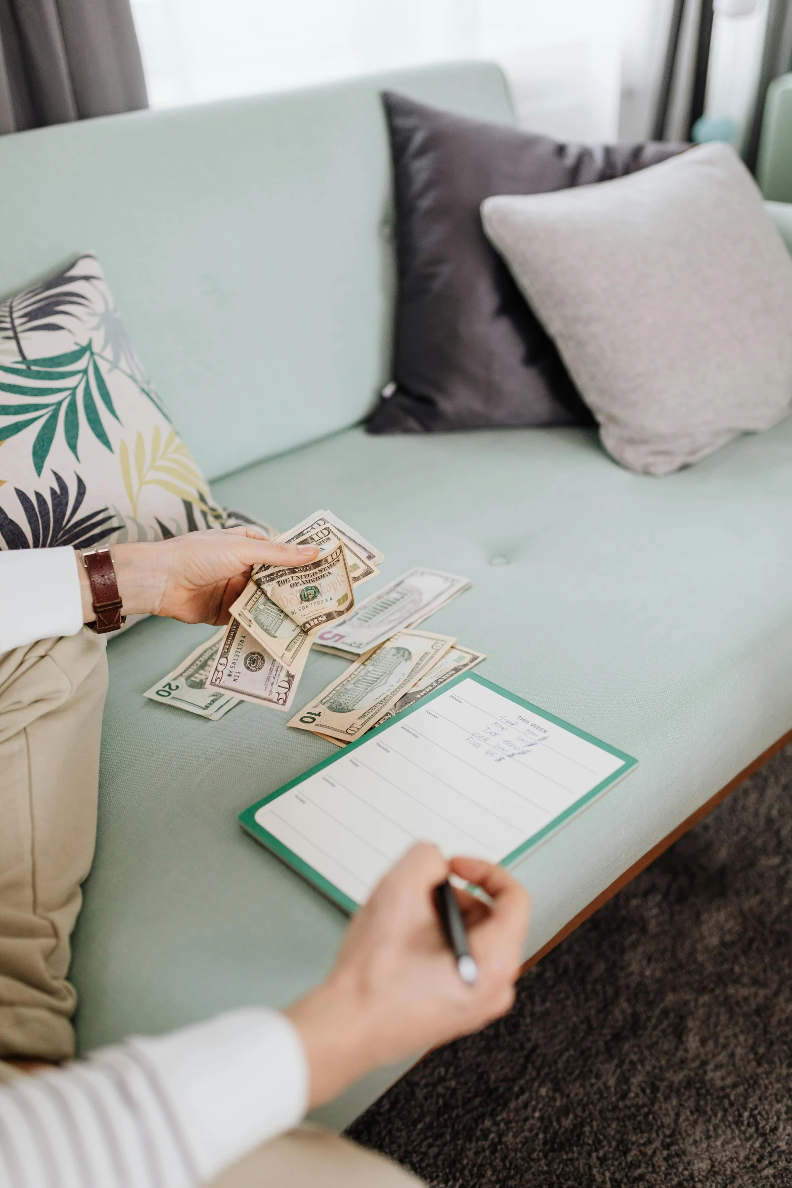 woman filling out money on the couch for someone to pay