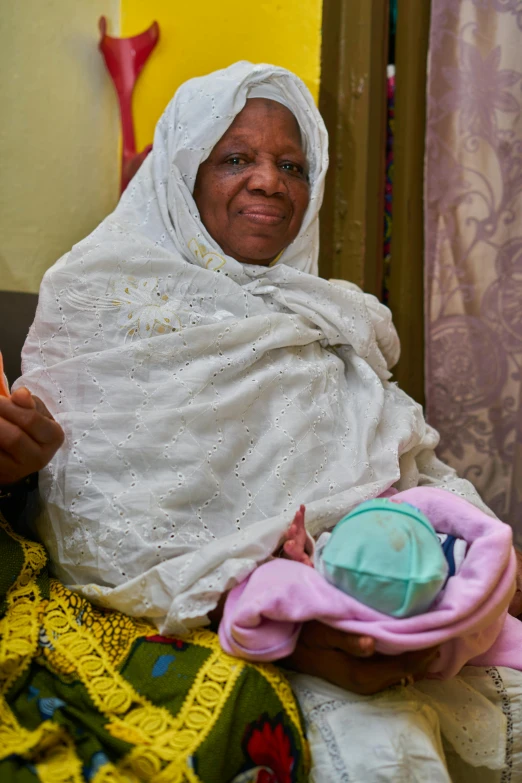 a woman is sitting down holding her child