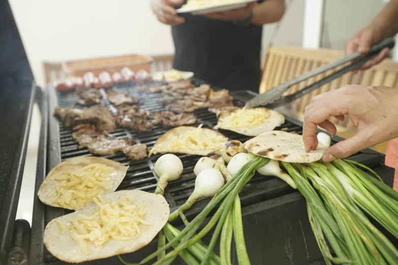 someone is preparing food on the grill to be eaten