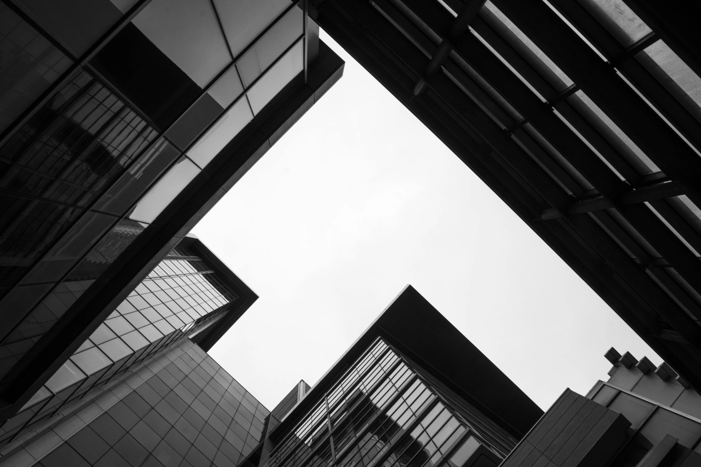 two office buildings viewed from below through some metal bars