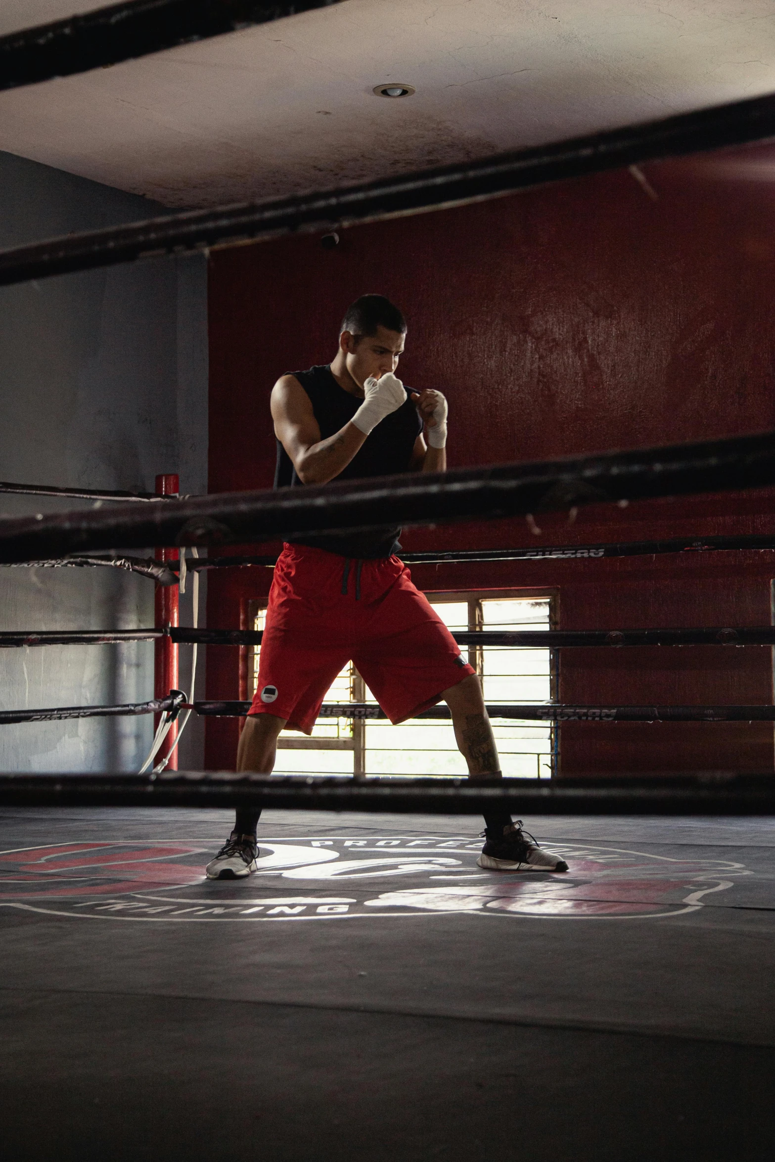 a man standing next to a boxing ring holding a glove