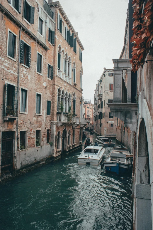 boats are parked along a waterway in front of buildings