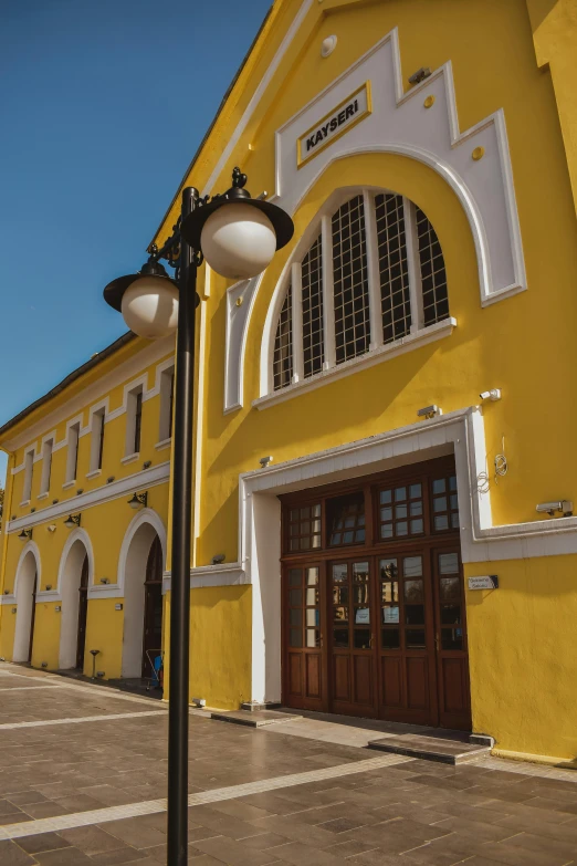 a very large yellow building with two door and an arch