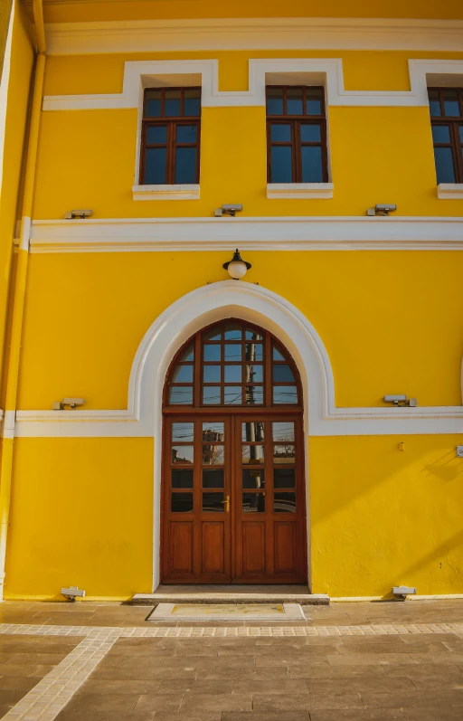 a building with a wooden door and two windows