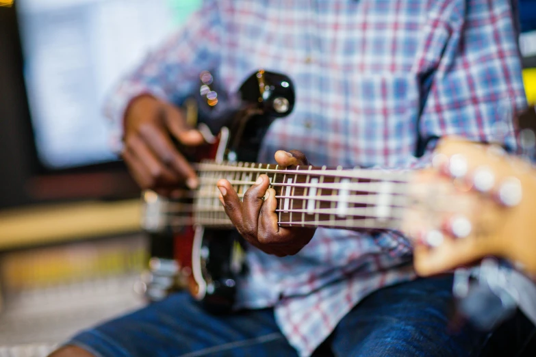 close up of a person playing bass guitar