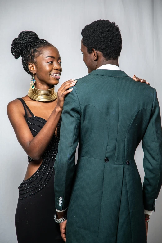 a woman adjusting the collar of a man