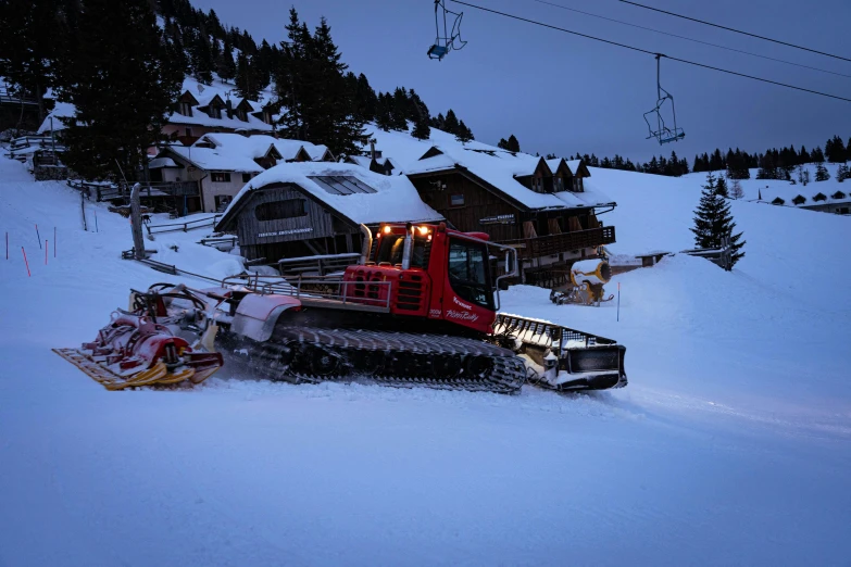 a ski slope with some snow equipment parked on it