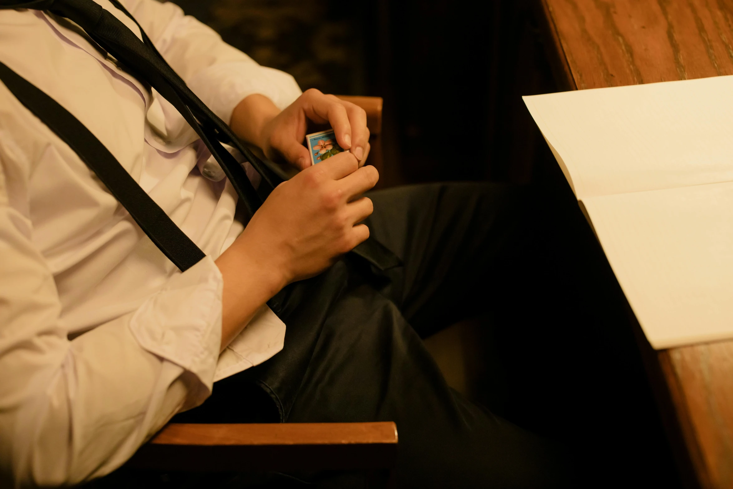 a person sitting down and holding up a smart phone