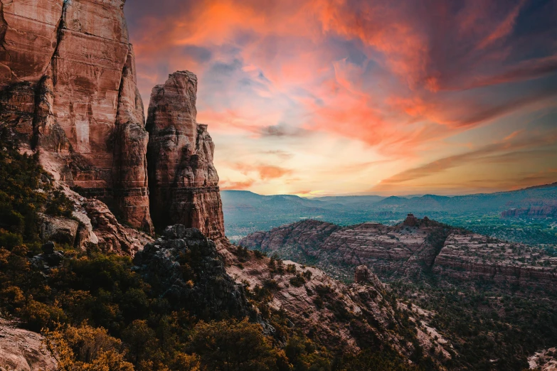 a sunset view from a mountain top in the distance