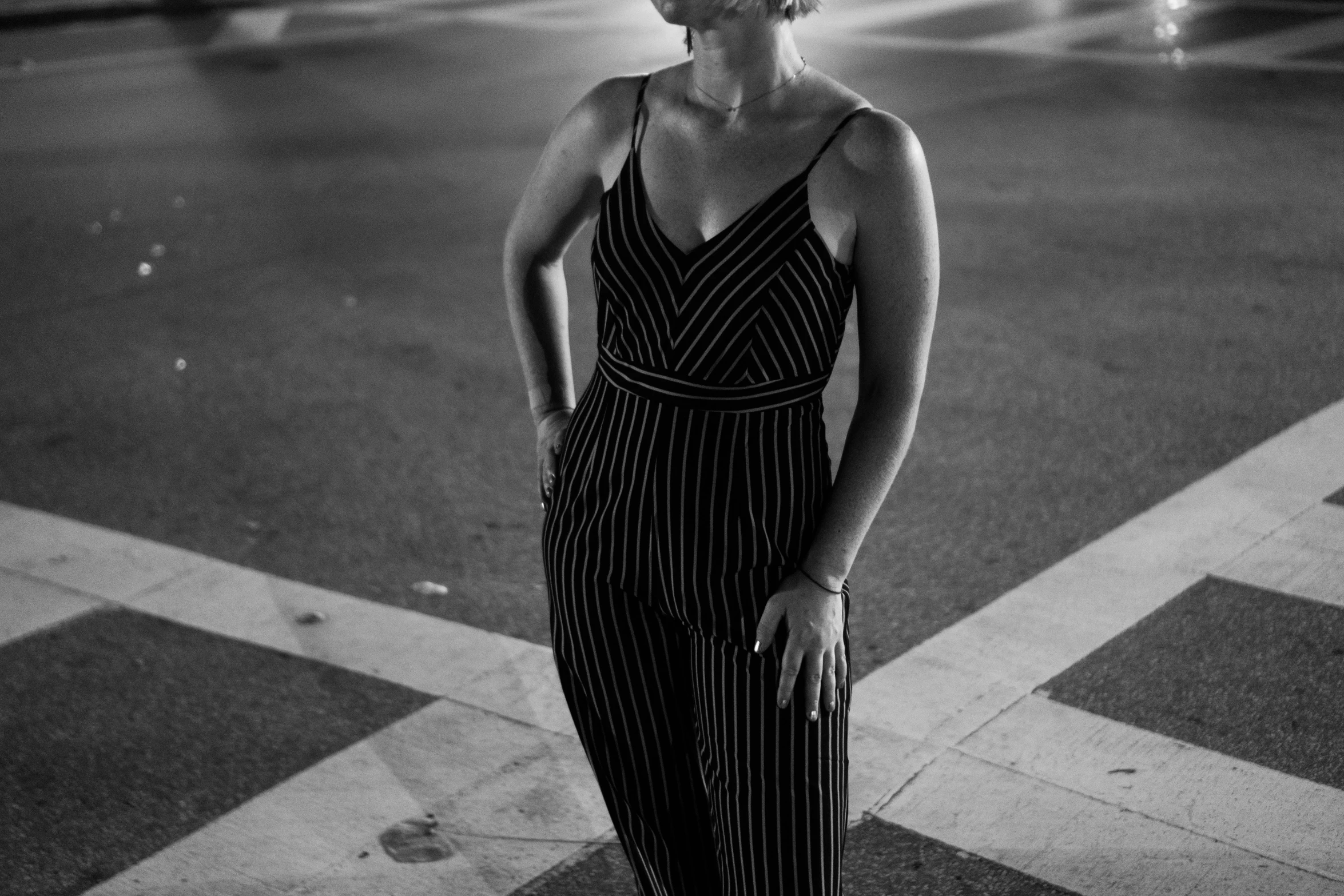 a woman standing on the side walk next to a street