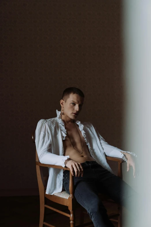 a woman sitting on top of a chair with her shirt over her chest