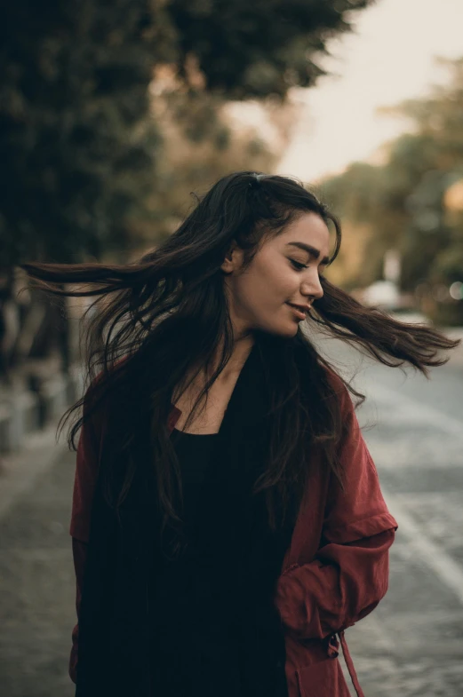 a woman walking down the street holding a cell phone to her ear