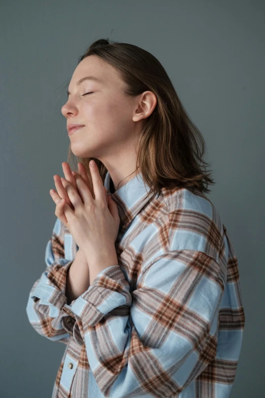 a woman with her eyes closed standing while praying