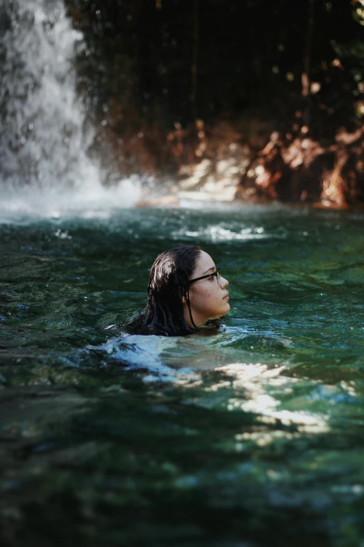 a woman with her eyes closed swimming in water