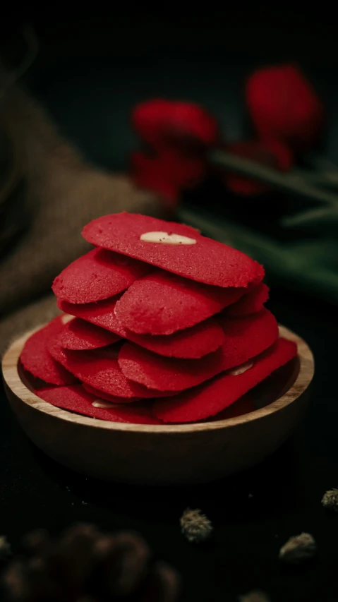 a wooden plate filled with red cake slices