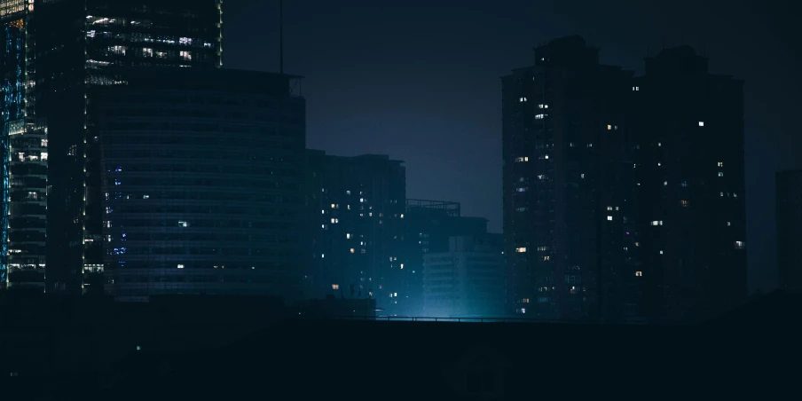 a night time scene of a high rise building with city lights
