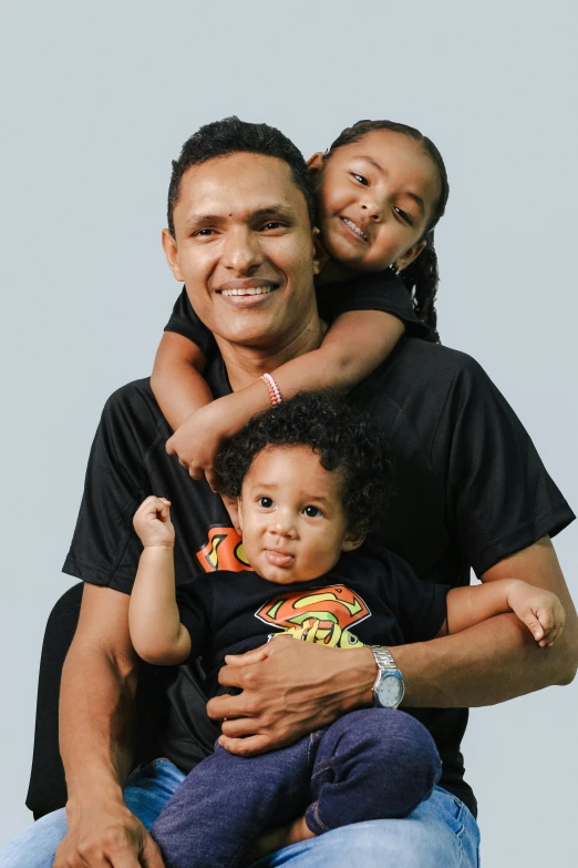 father with two children posing for a po