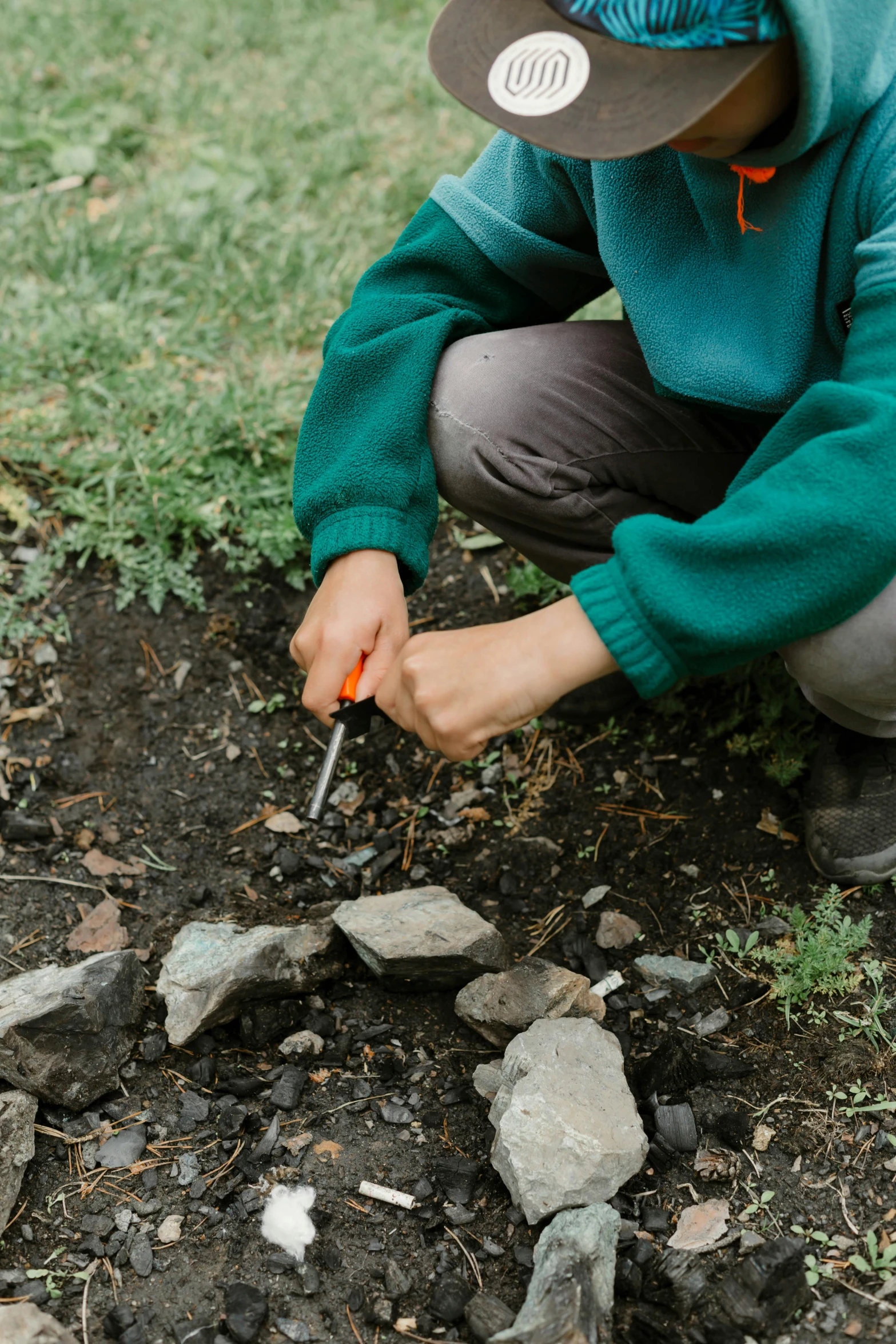 a little boy putting rocks together to plant