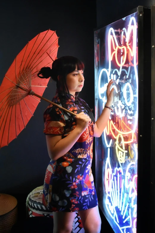 a woman is standing in front of a neon light display