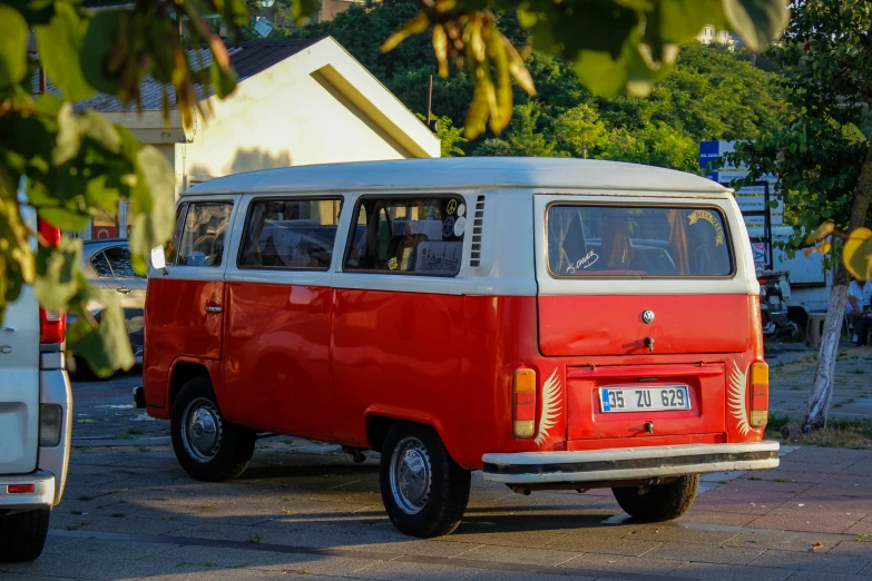 an old, red and white van is parked in a driveway