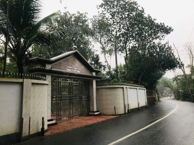 a paved road with trees and fence along side