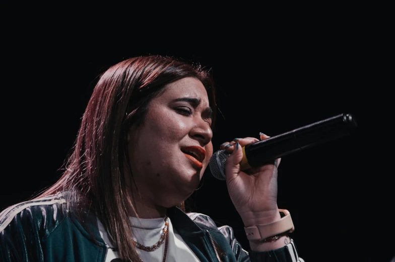 a woman holding a microphone to her mouth