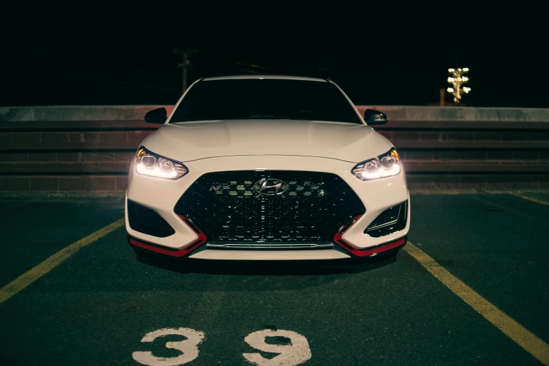 the front end of a white sports car with numbers 9 and nine on it