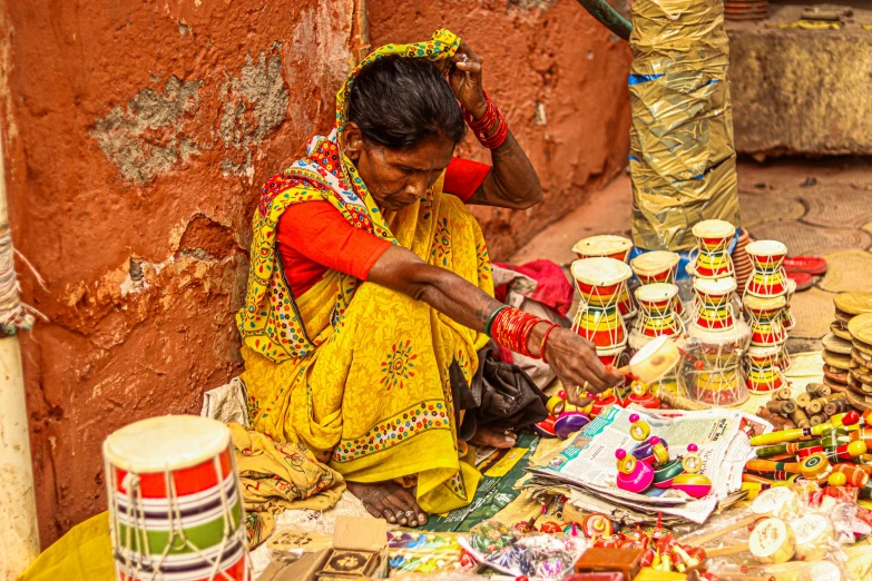 an indian woman selling jewelry and crafting on the street