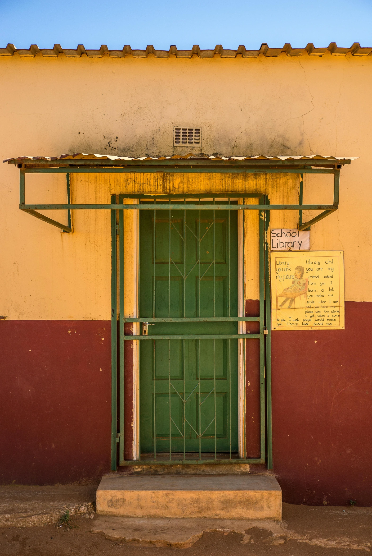 a doorway with two green doors near a red and yellow building