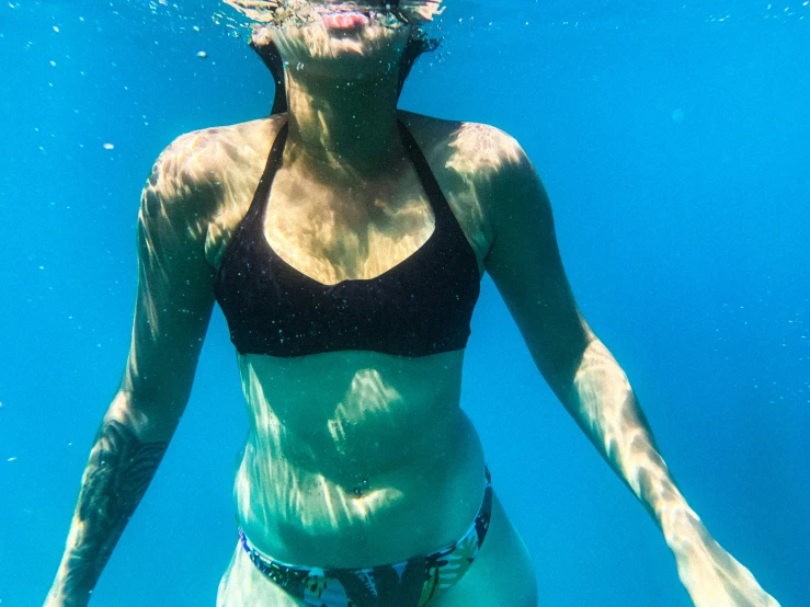 the woman in the water is wearing a black bikini