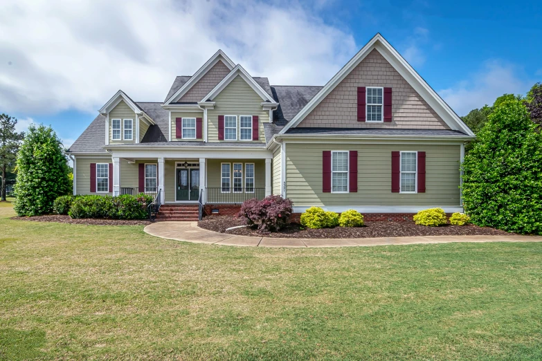 a large gray house in a green yard