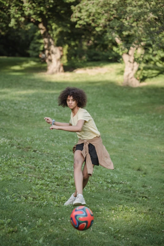 a little girl that is standing near a ball