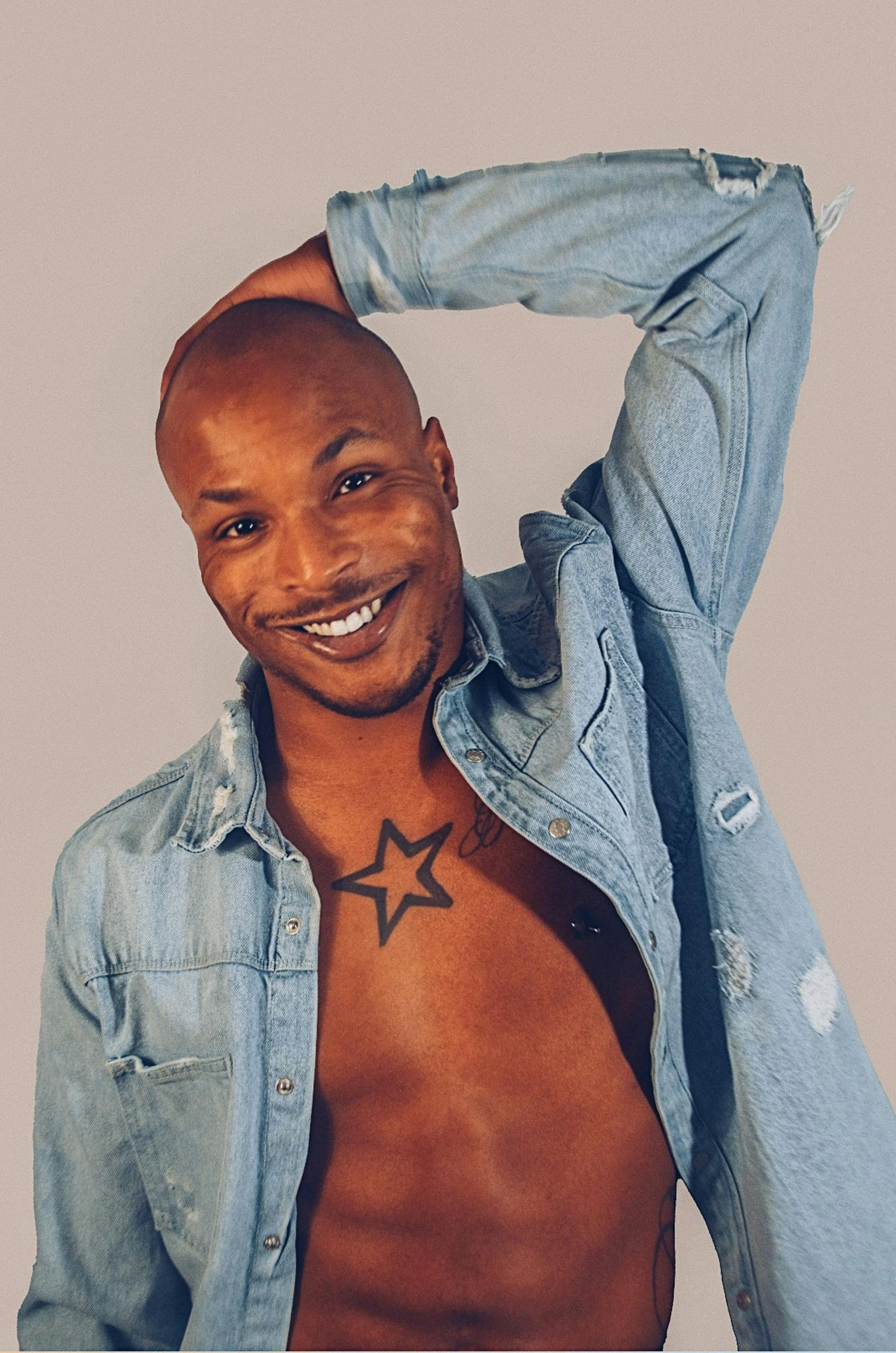 a shirtless man with a small star on his chest